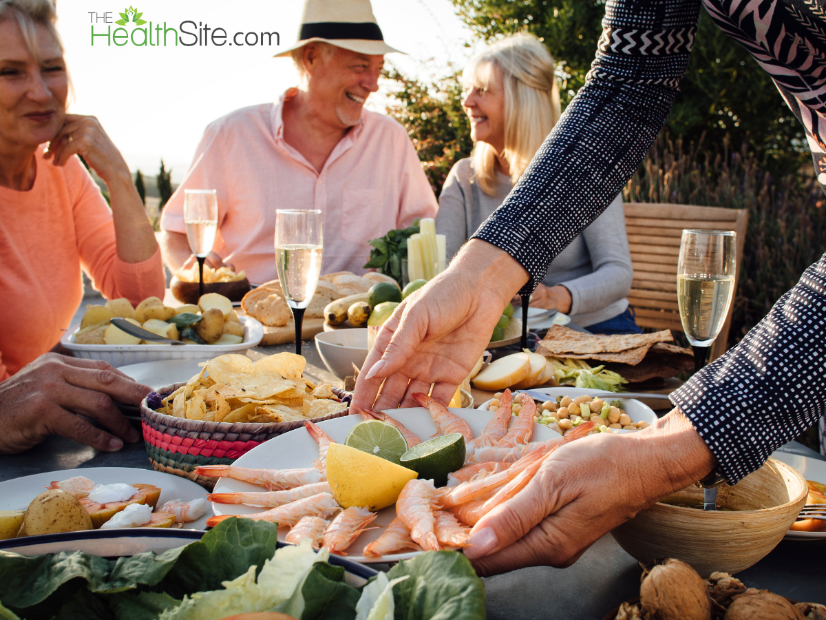 A variety of Mediterranean dishes including grilled seafood, hummus, tabbouleh salad, olives, and pita bread arranged on a table.